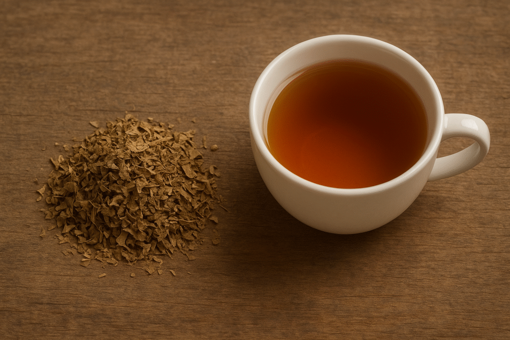 Sobre uma mesa de madeira uma xícara  de porcelana com chá ao lado de um montinho de folhas secas de insulina vegetal.
