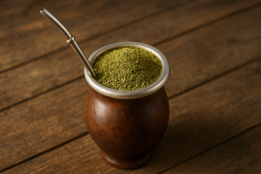 Sobre uma mesa de madeira uma cúia cheia de erva mate no qual é servido o chimarrão.
